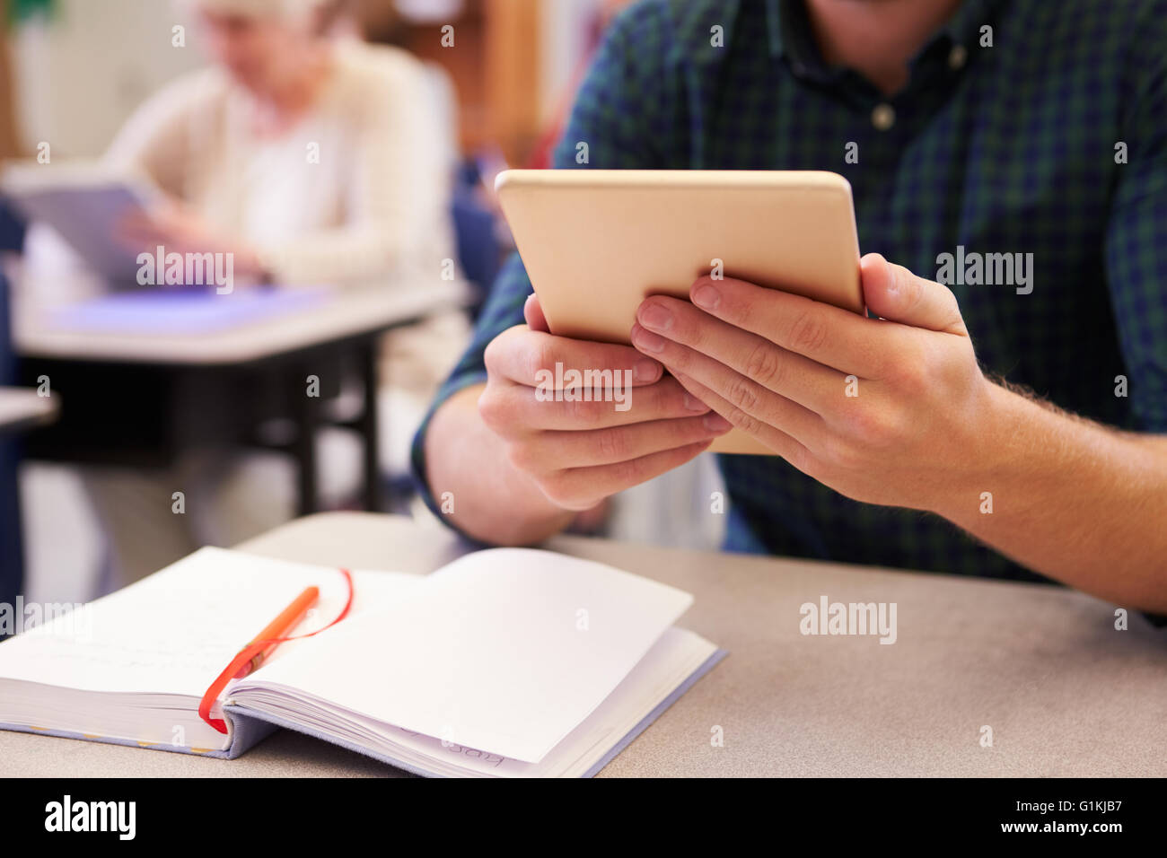 Mann an Erwachsenenbildung Klasse Holding Tablet, Hände-detail Stockfoto