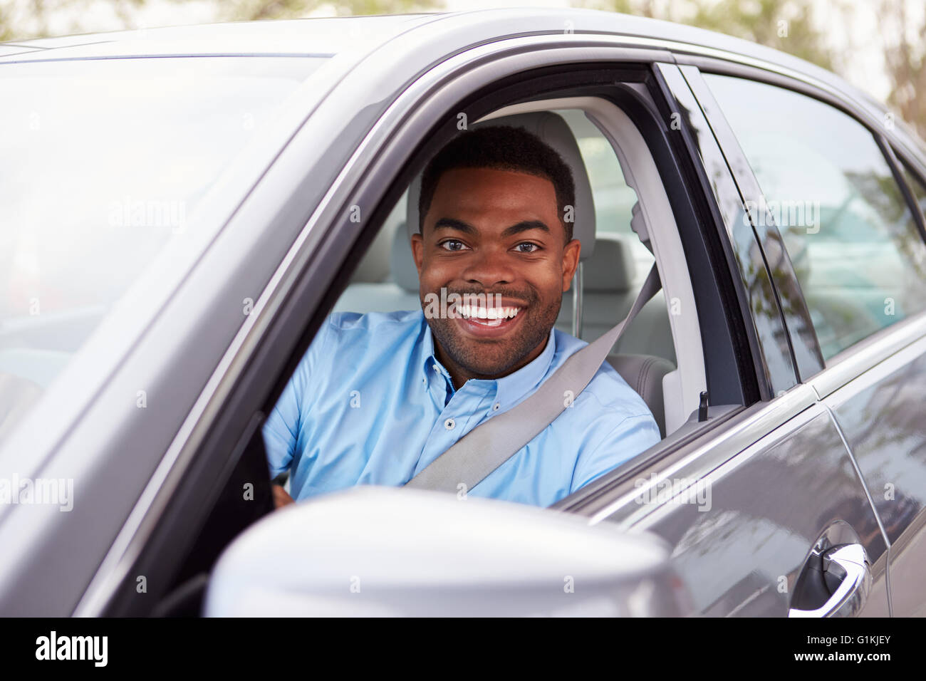 Afrikanische amerikanische männliche Fahrer auf Kamera durch Autofenster Stockfoto