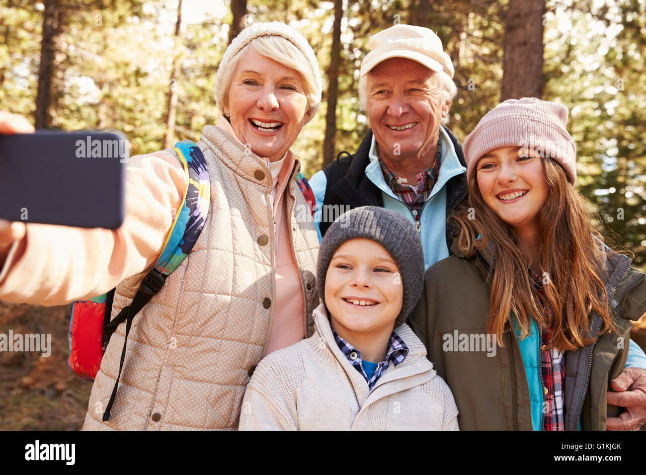 Ältere Frau, die im freien Selfie mit Enkelkindern und Ehepartner Stockfoto