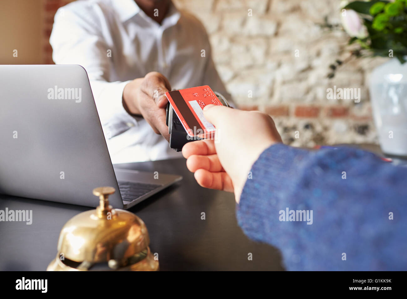 Gast macht Kartenzahlung am Check-in-Schalter des Hotels, detail Stockfoto