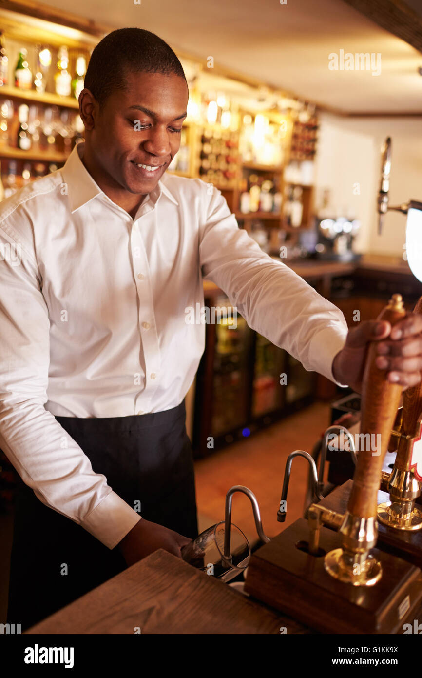Ein junger schwarzer Mann hinter einer Bar arbeitet Zubereitung Stockfoto