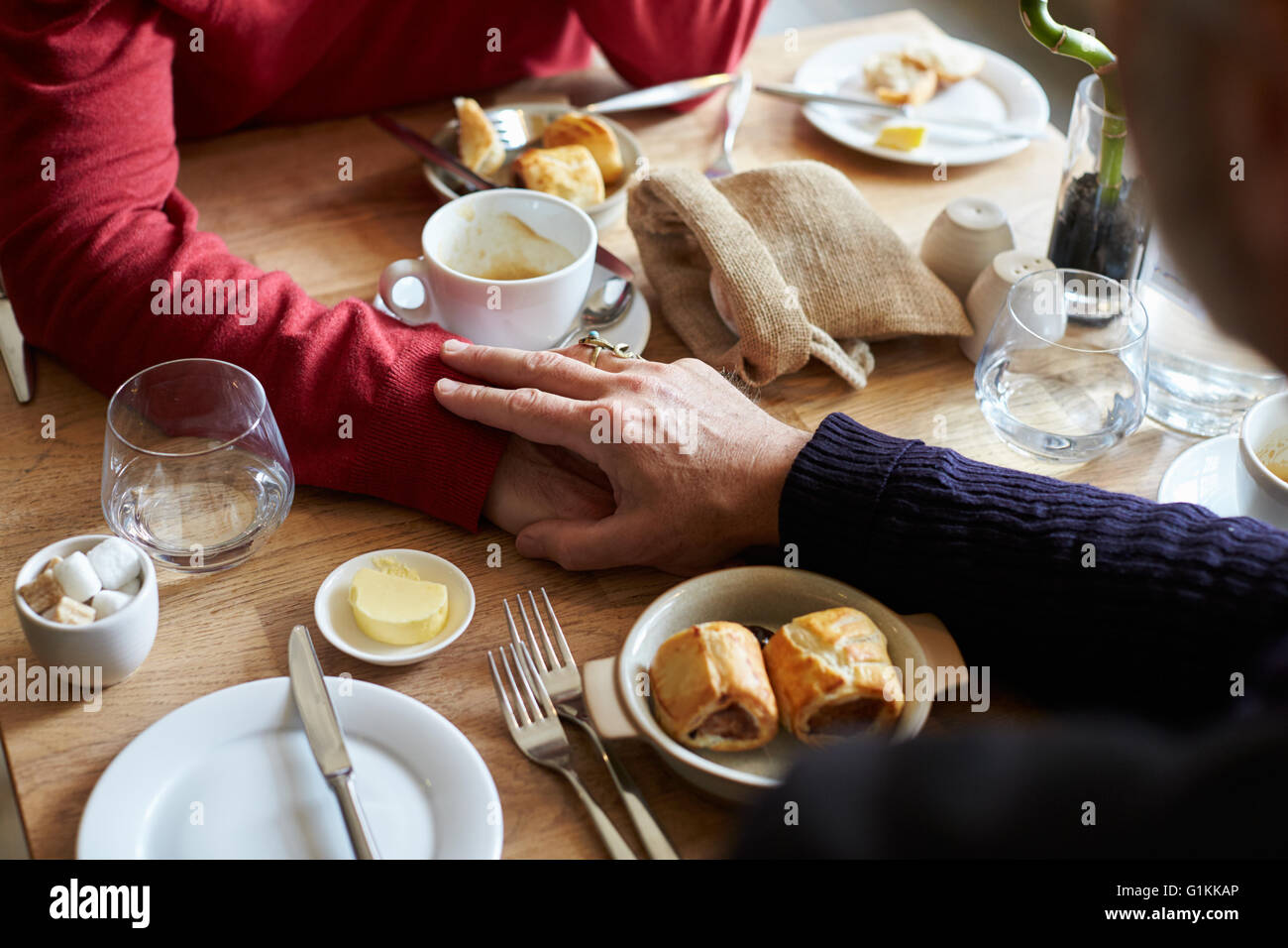 Männlichen Partner Hand in Hand am Tisch im Restaurant, Hände detail Stockfoto