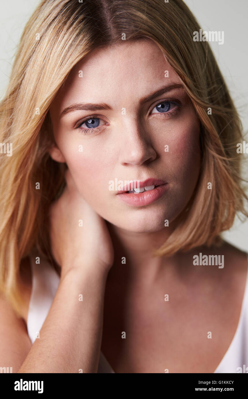 Blonde Frau, die Kamera, die hand am Hals, vertikale Stockfoto