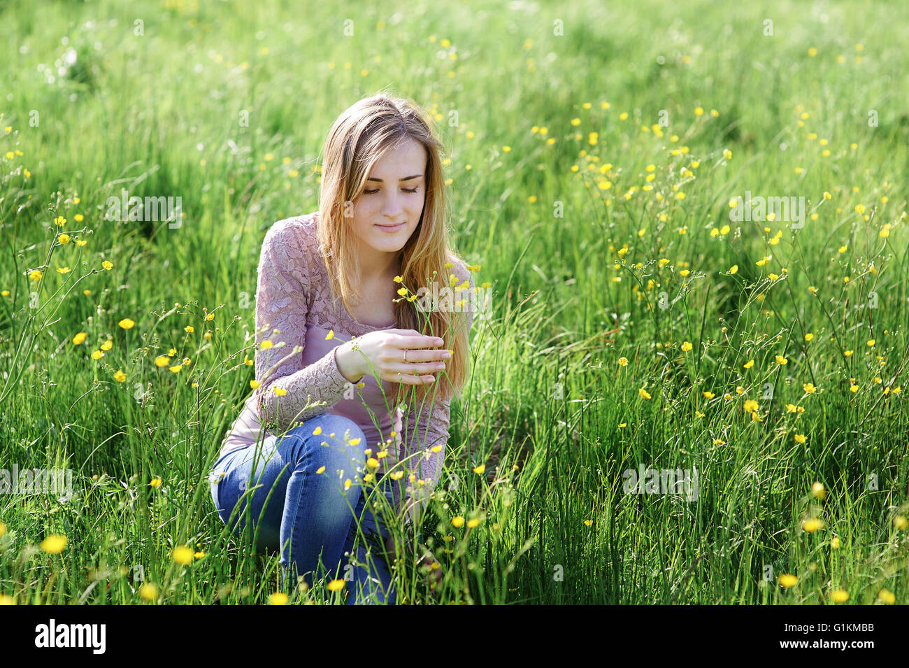junge Frau Blumenpflücken auf einer Sommerwiese Stockfoto