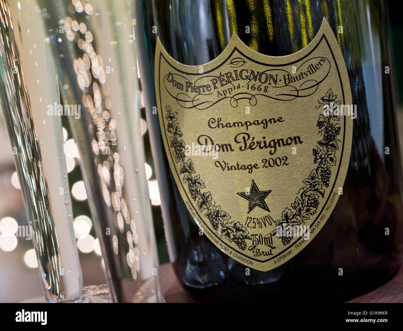 Frisch gegossen Flöten der Jahrgang 2002 Dom Perignon Luxus Champagner mit funkelnden Lichter im Hintergrund Stockfoto