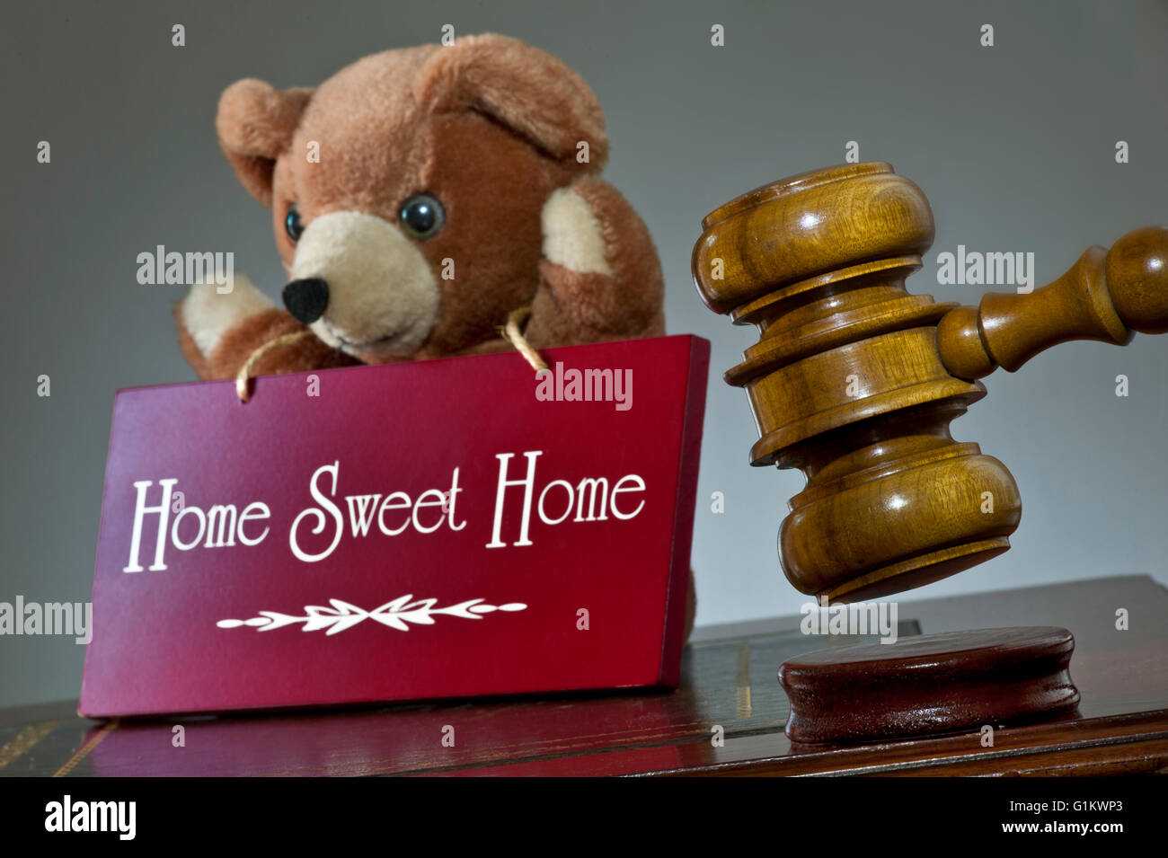 HOME VERKAUF KONZEPT Haus Versteigerung Konzept, auktionatoren Hammer & 'Home Sweet Home'-Schild mit Teddy's Kind gebären im Support Stockfoto