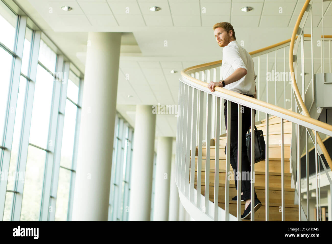 Junger Geschäftsmann Treppensteigen im Bürogebäude Stockfoto