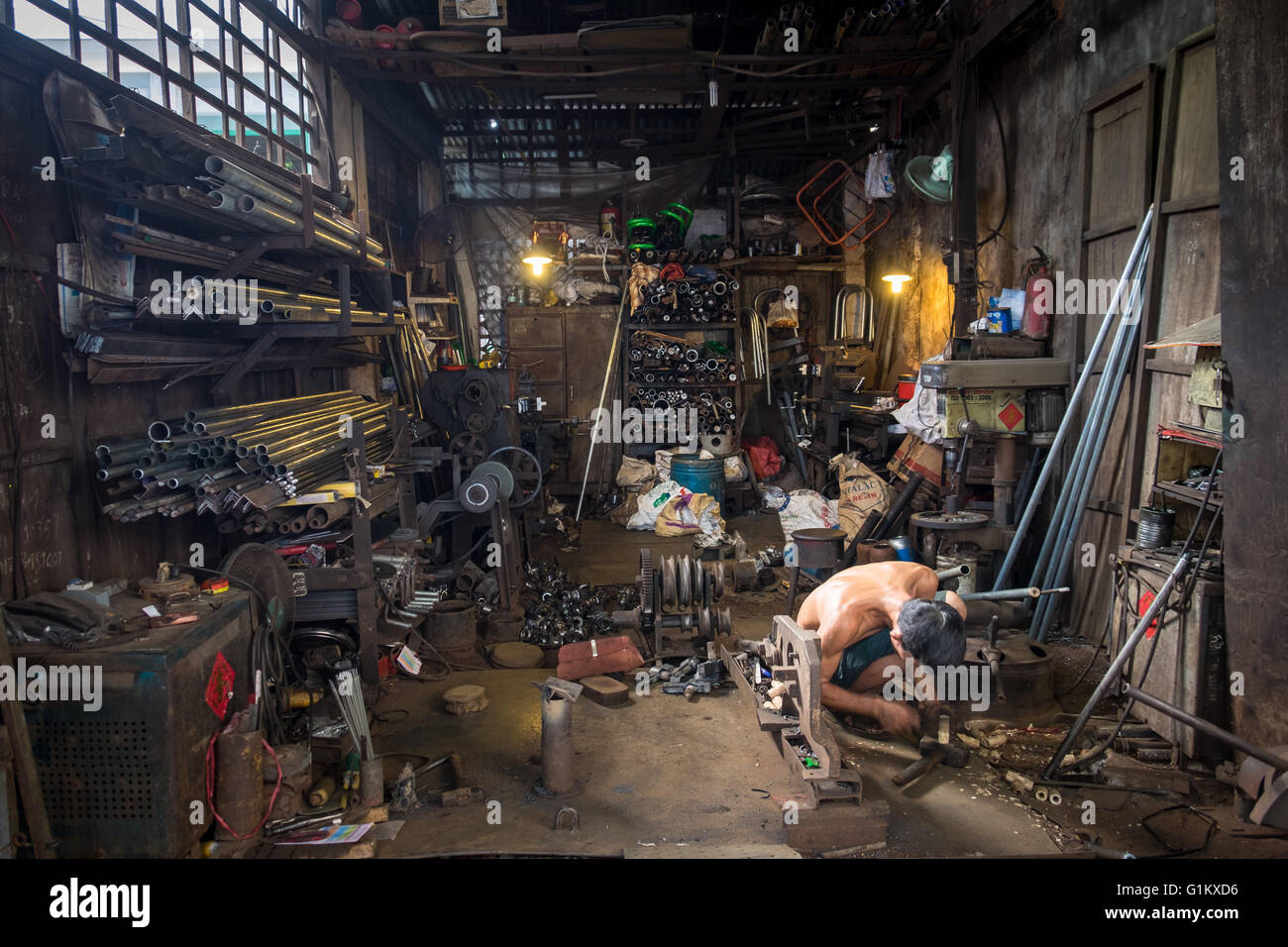 Ein Mann, der arbeitet in seiner Metallwerkstatt im Cho An Lac in Can Tho Stockfoto