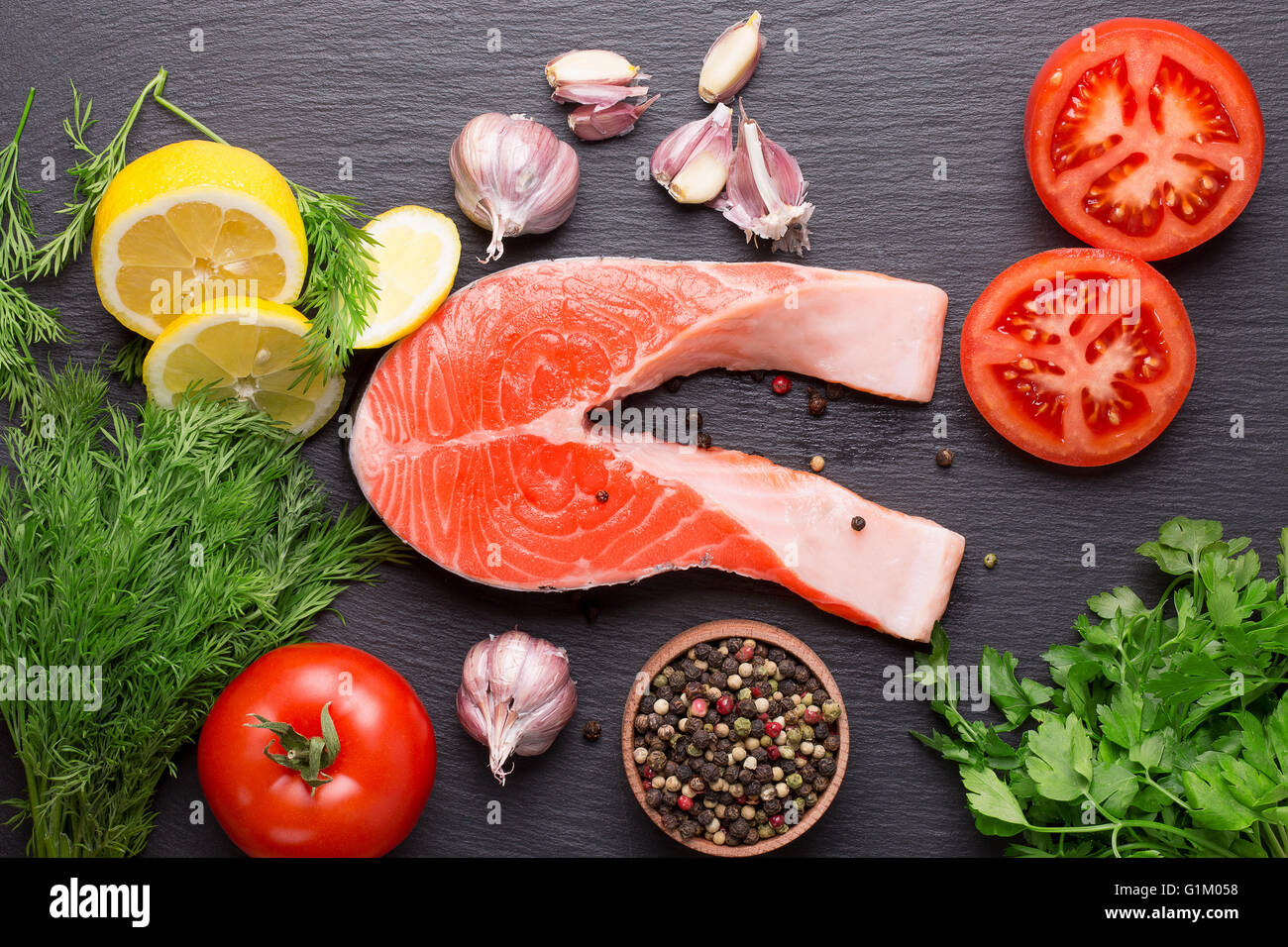 roter Fisch Steak mit Gewürzen und Gemüse auf einem Schiefer Tisch. Stockfoto