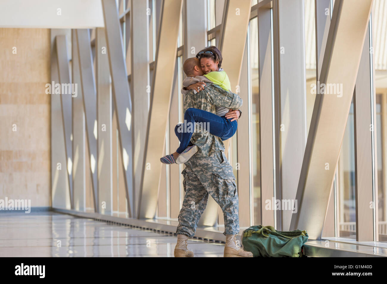 Zurückkehrenden Soldaten Gruß Freundin in Flughafen Stockfoto