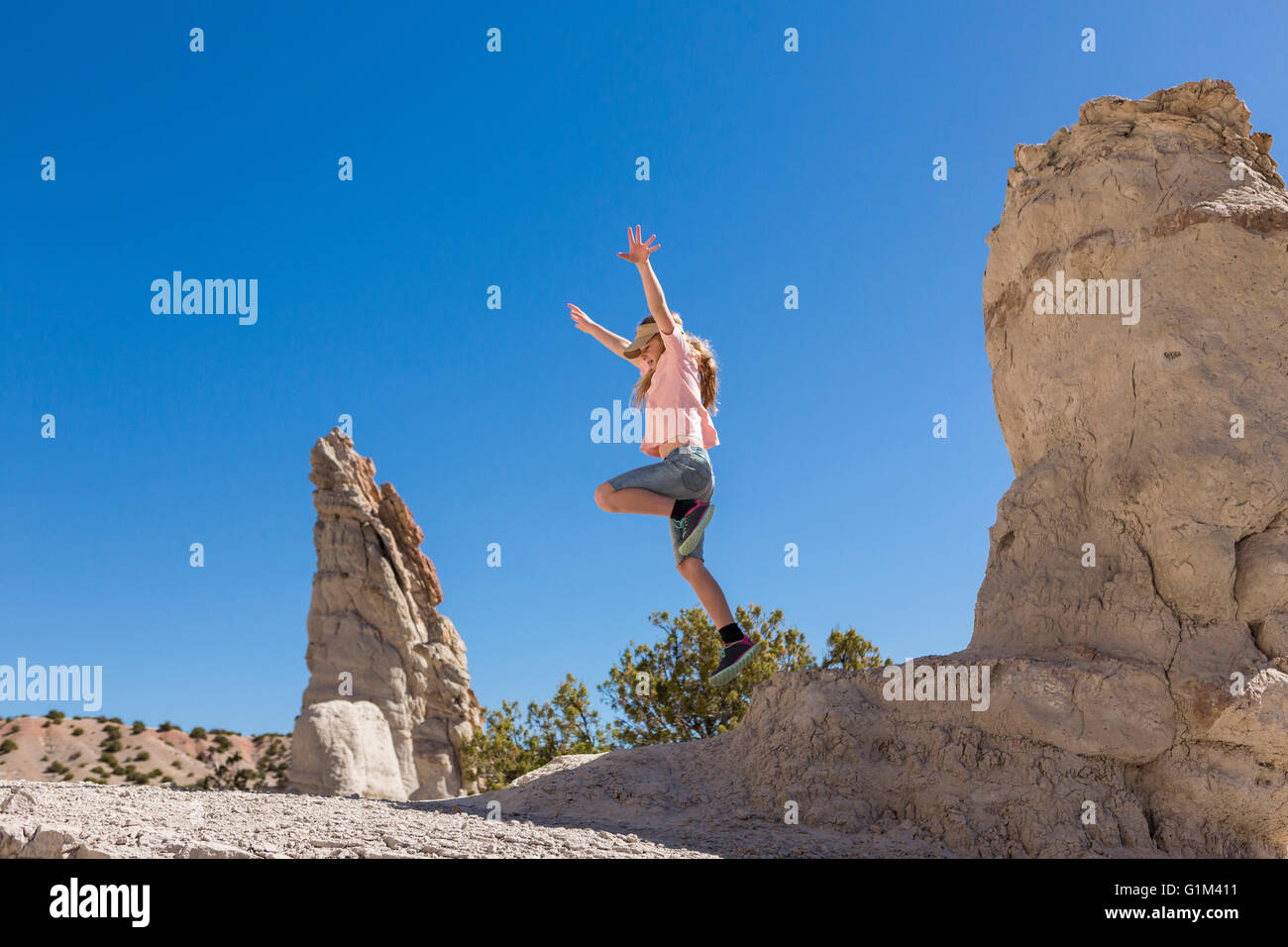 Kaukasische Mädchen abspringen Felsformation Stockfoto