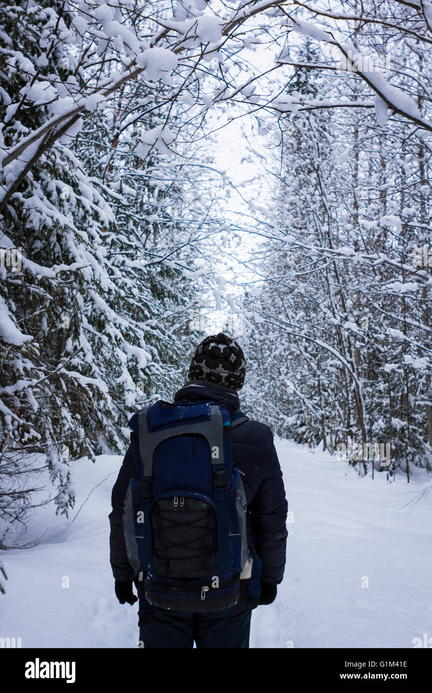 Kaukasische Wanderer stehend im verschneiten Wald Stockfoto