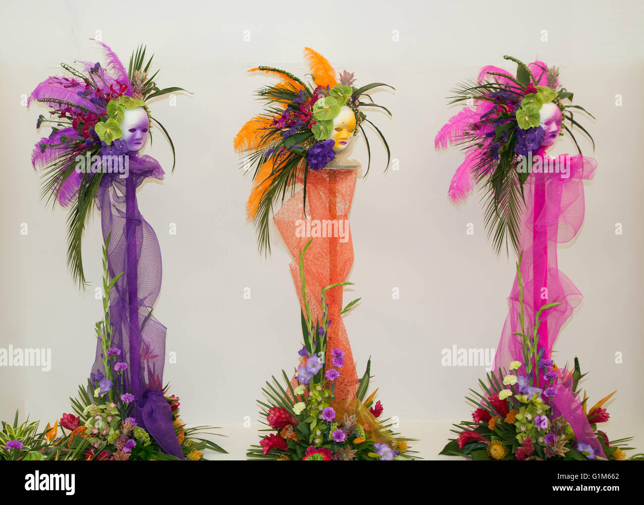 Blumengestecke mit venezianischen Masken Stockfoto