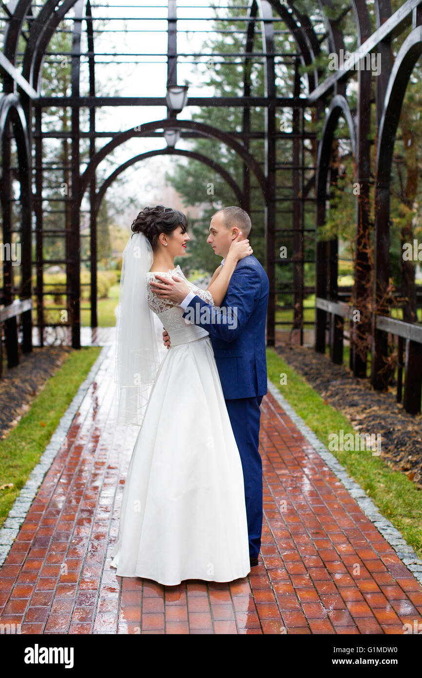 Paar im Regen stehen am Tag Hochzeit Stockfoto