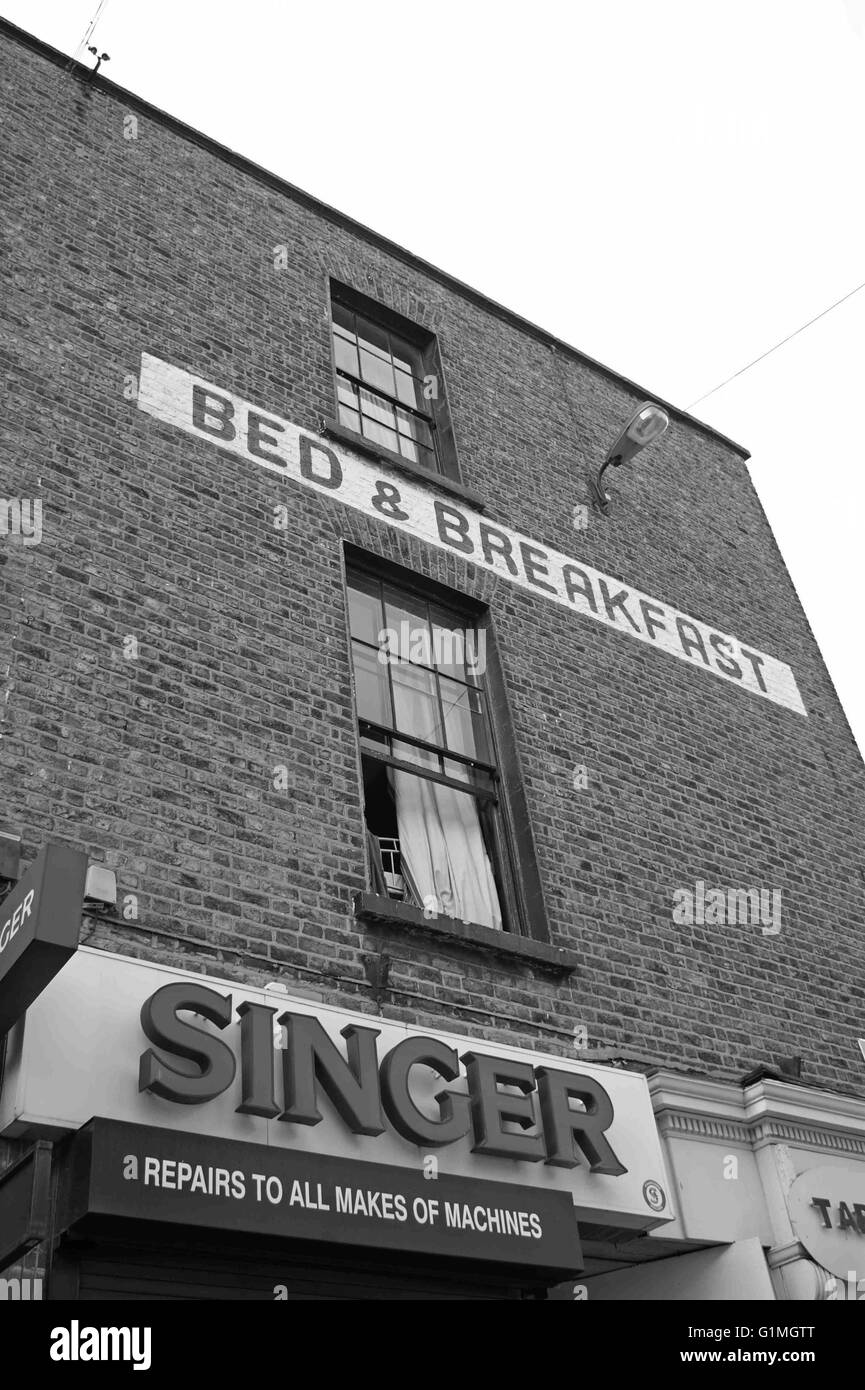 Alte irische Dublin Backsteingebäude, Bed &amp; Breakfast, Sänger Werbung, alte Fenster öffnen. Schwarz / weiß Fotografie Stockfoto