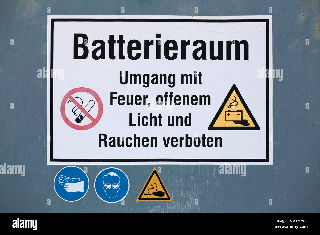 Warnschild am Batterieraum mit verschiedenen Symbolen. Der Text bedeutet: Batterieraum - Feuer, offenes Feuer und Rauchen sind verboten. Stockfoto