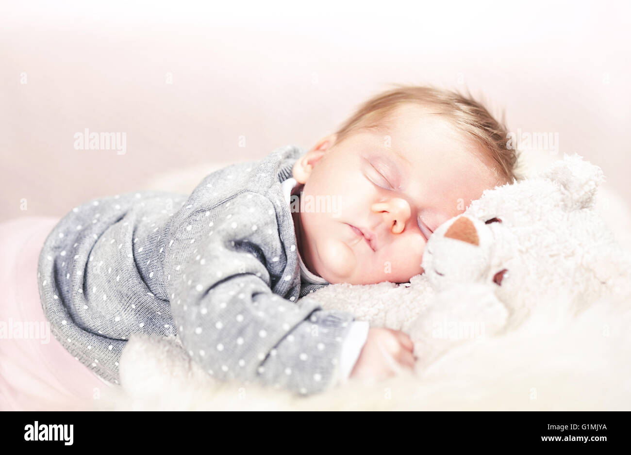 femal Baby auf klassisch weißem Fell schlafen Stockfoto