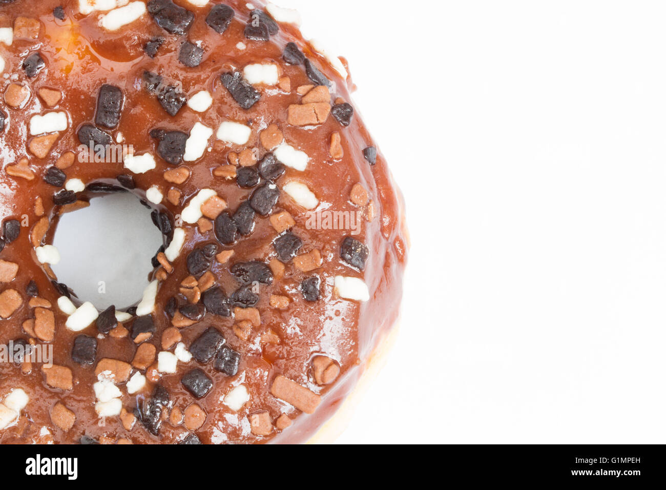 Ein großer Donut mit Schokoladenglasur und Streusel zeigt ihr Loch auf einem isolierten weißen Hintergrund. Stockfoto