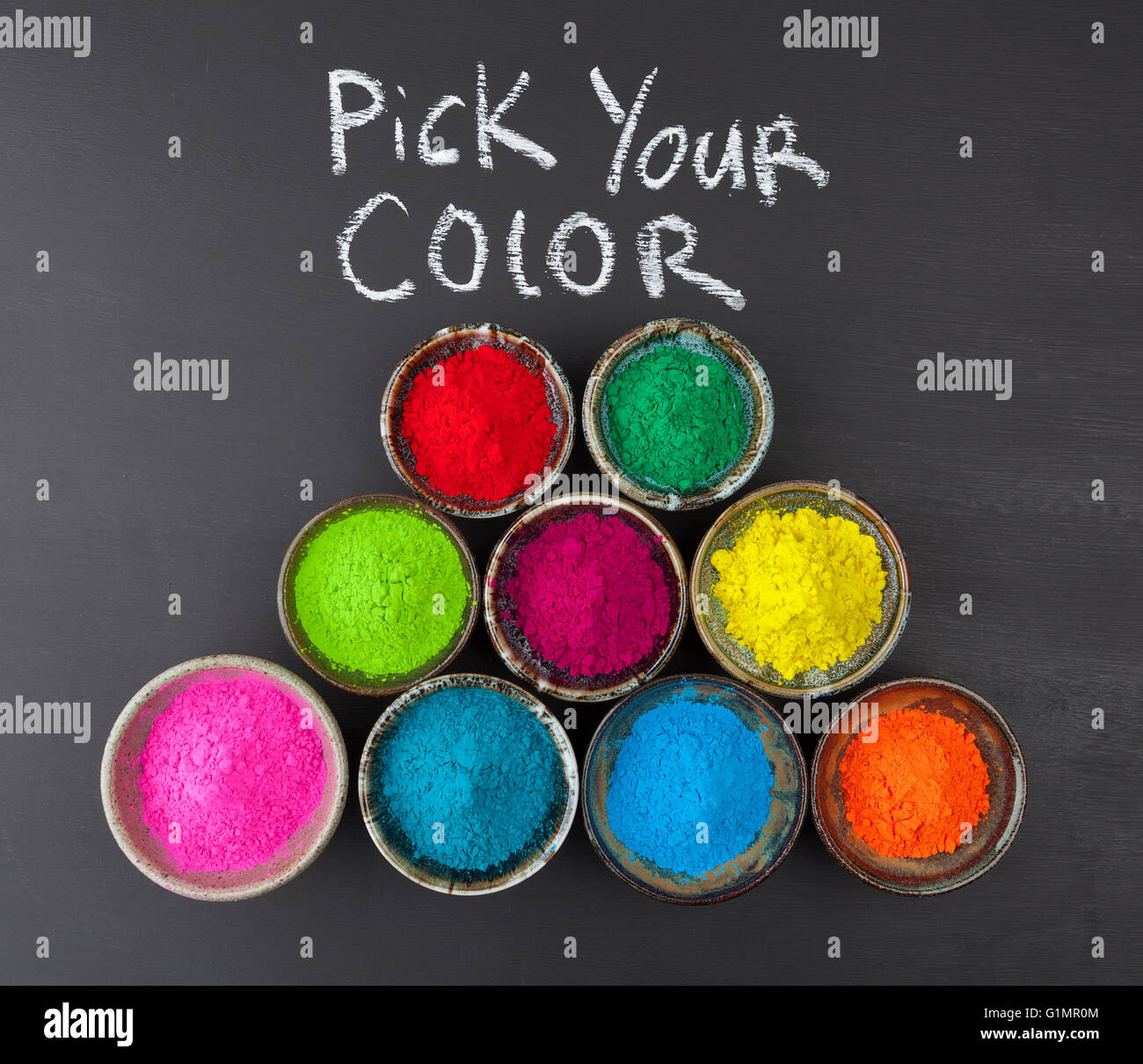 Wählen Sie Ihr Farbkonzept mit bunt gefärbten Pulver in Keramikbechern an Tafel dargestellt. Stockfoto