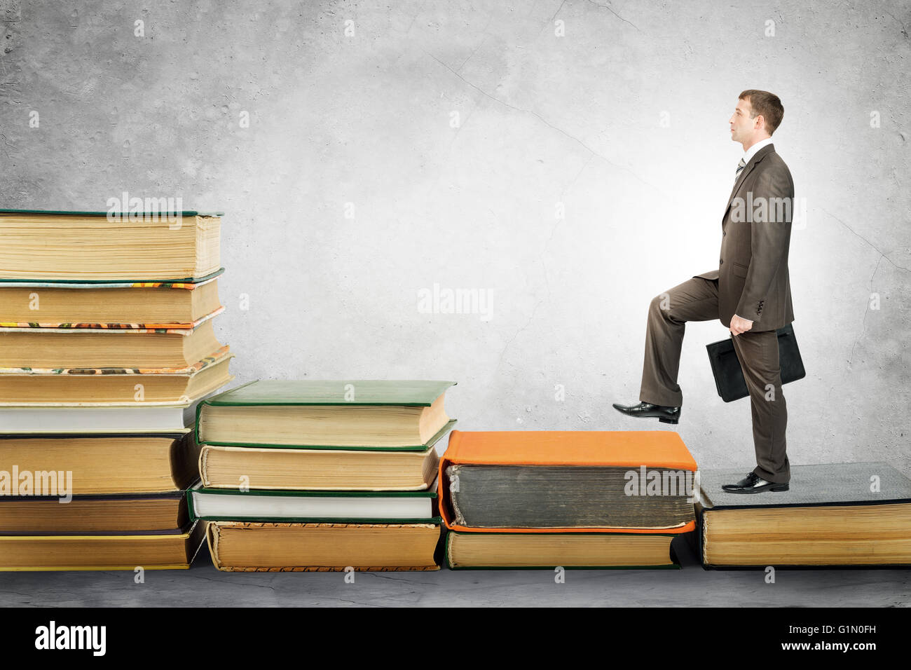 Geschäftsmann mit Portfolio steigt Treppen Bücher Stockfoto