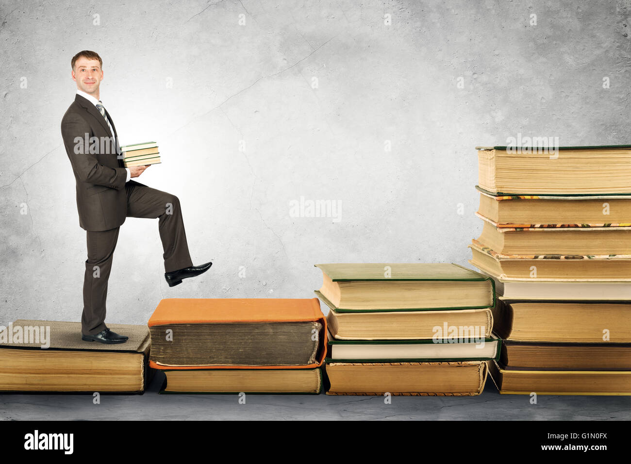 Geschäftsmann trägt Stapel von Büchern und geht auf Stockfoto