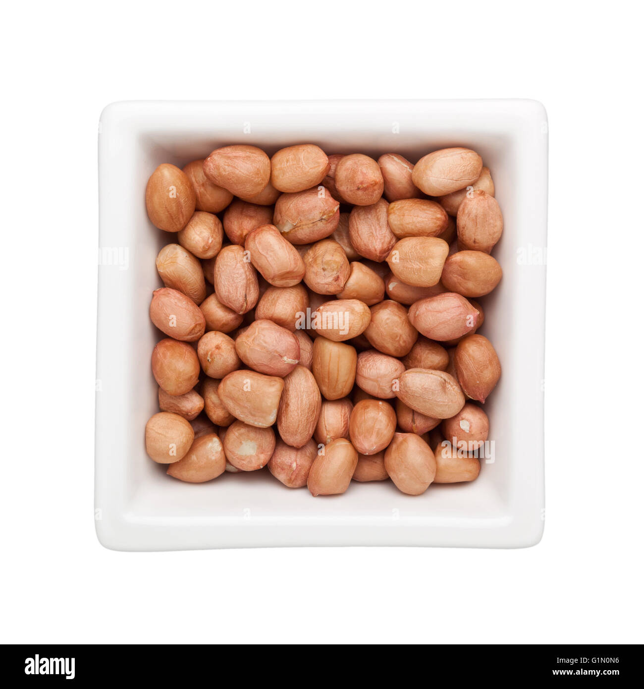 Geschälte Erdnüsse in eine quadratische Schale isoliert auf weißem Hintergrund Stockfoto
