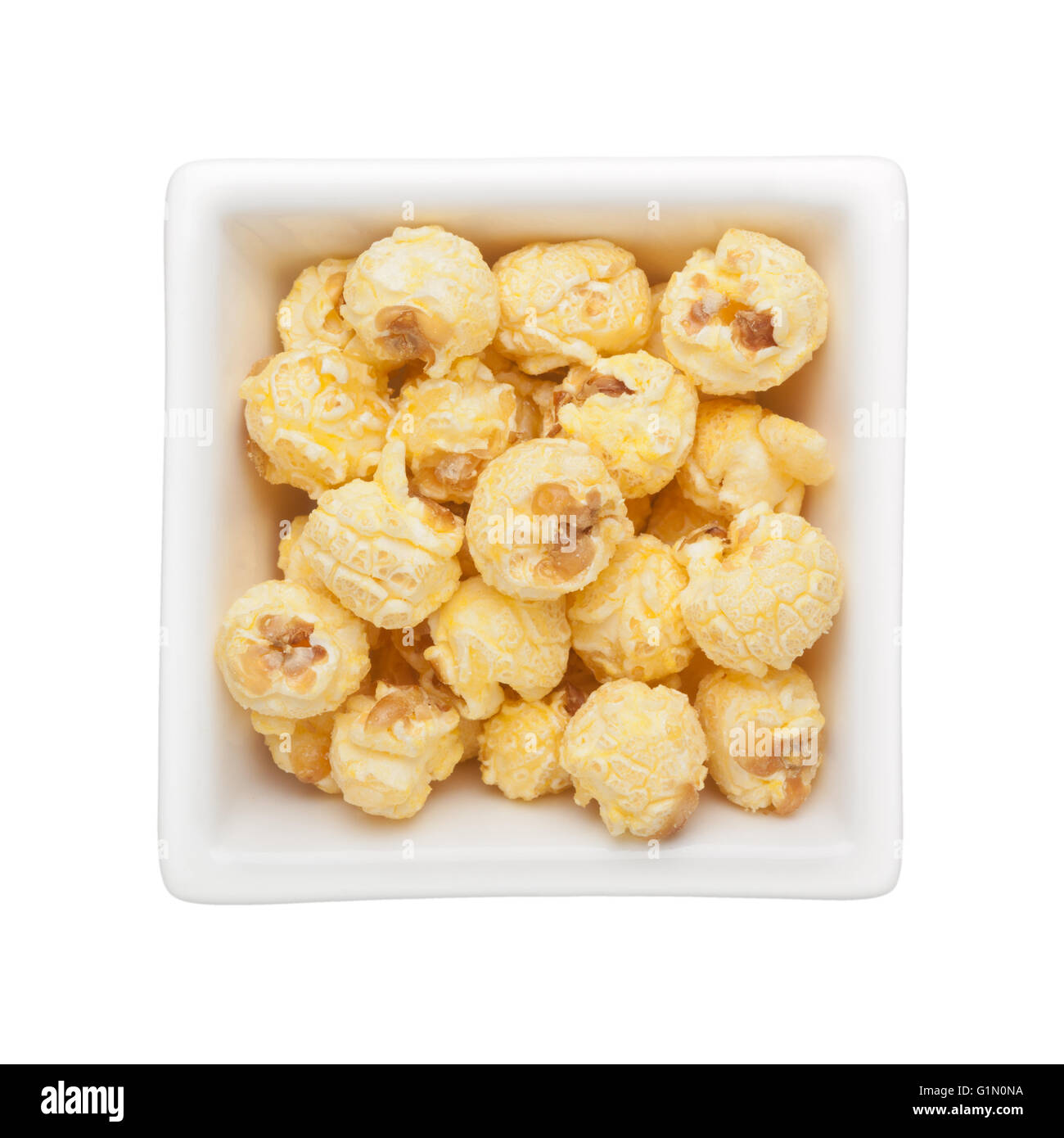 Karamell Popcorn in eine quadratische Schale isoliert auf weißem Hintergrund Stockfoto