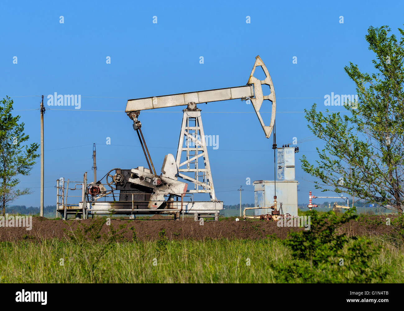 Alte Öl-Bohrschwengels auf der Sommerwiese Stockfoto