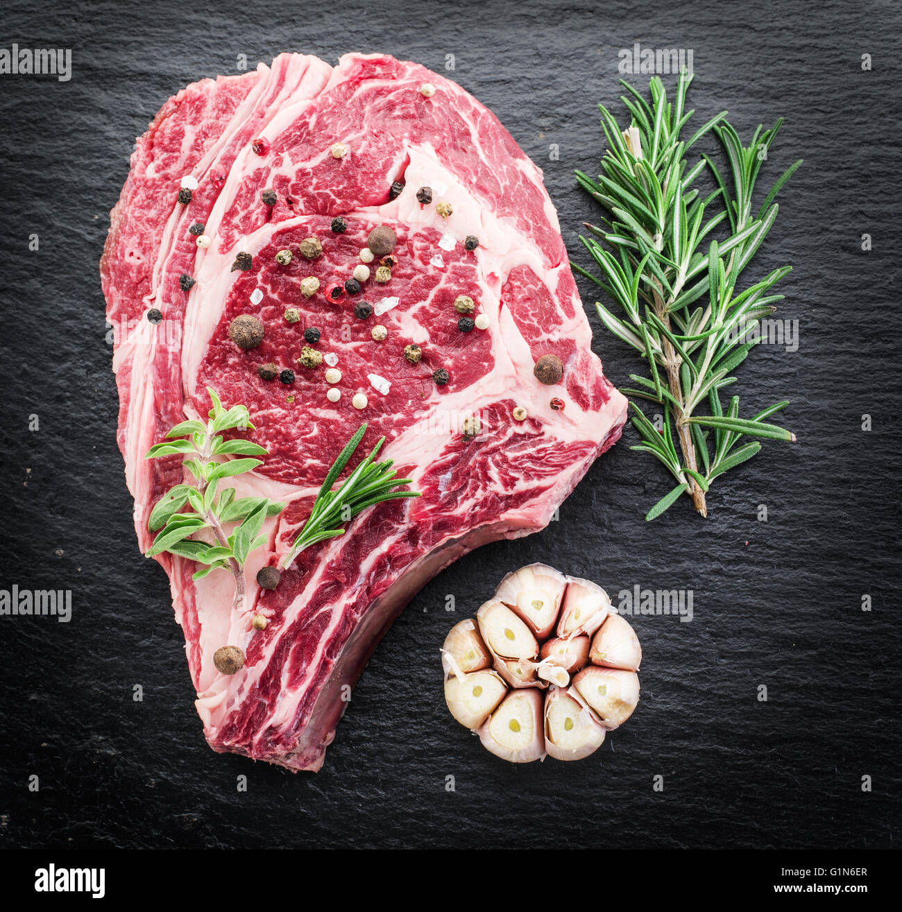 Rib-Eye Steak mit Gewürzen auf dem schwarzen Hintergrund. Stockfoto