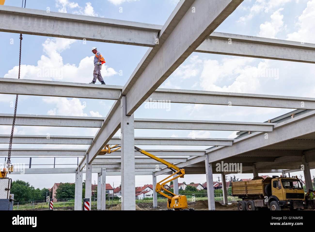 Bauarbeiter ist Fuß über auf den Aufbau von Betonbalken ohne ordnungsgemäße Sicherheitsausrüstung. Stockfoto