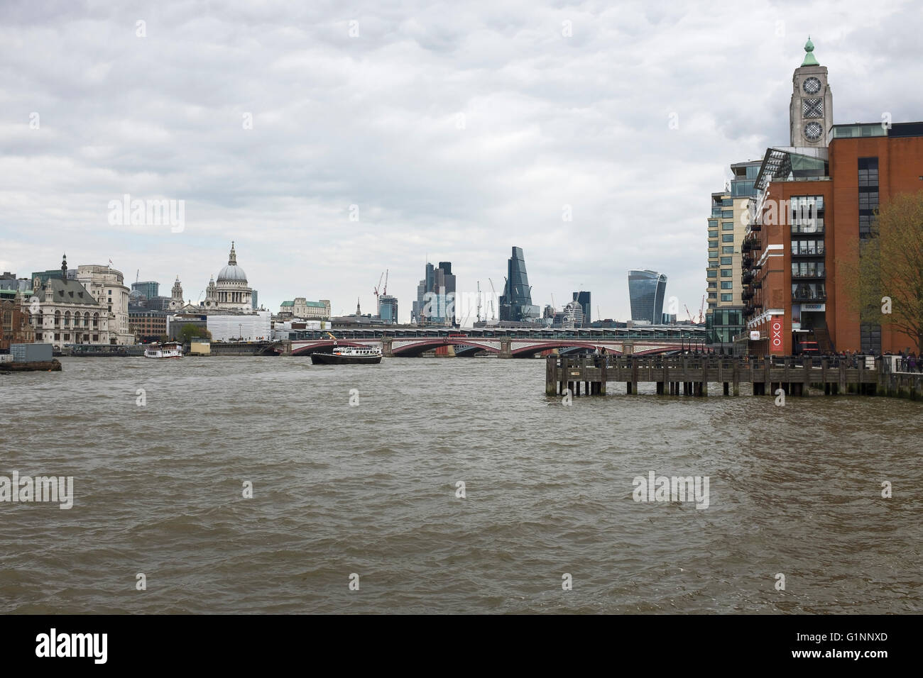 Blick über den Fluss Themse in London gegenüber der Oxo Tower, St Pauls Cathedral und das Bankenviertel Stockfoto