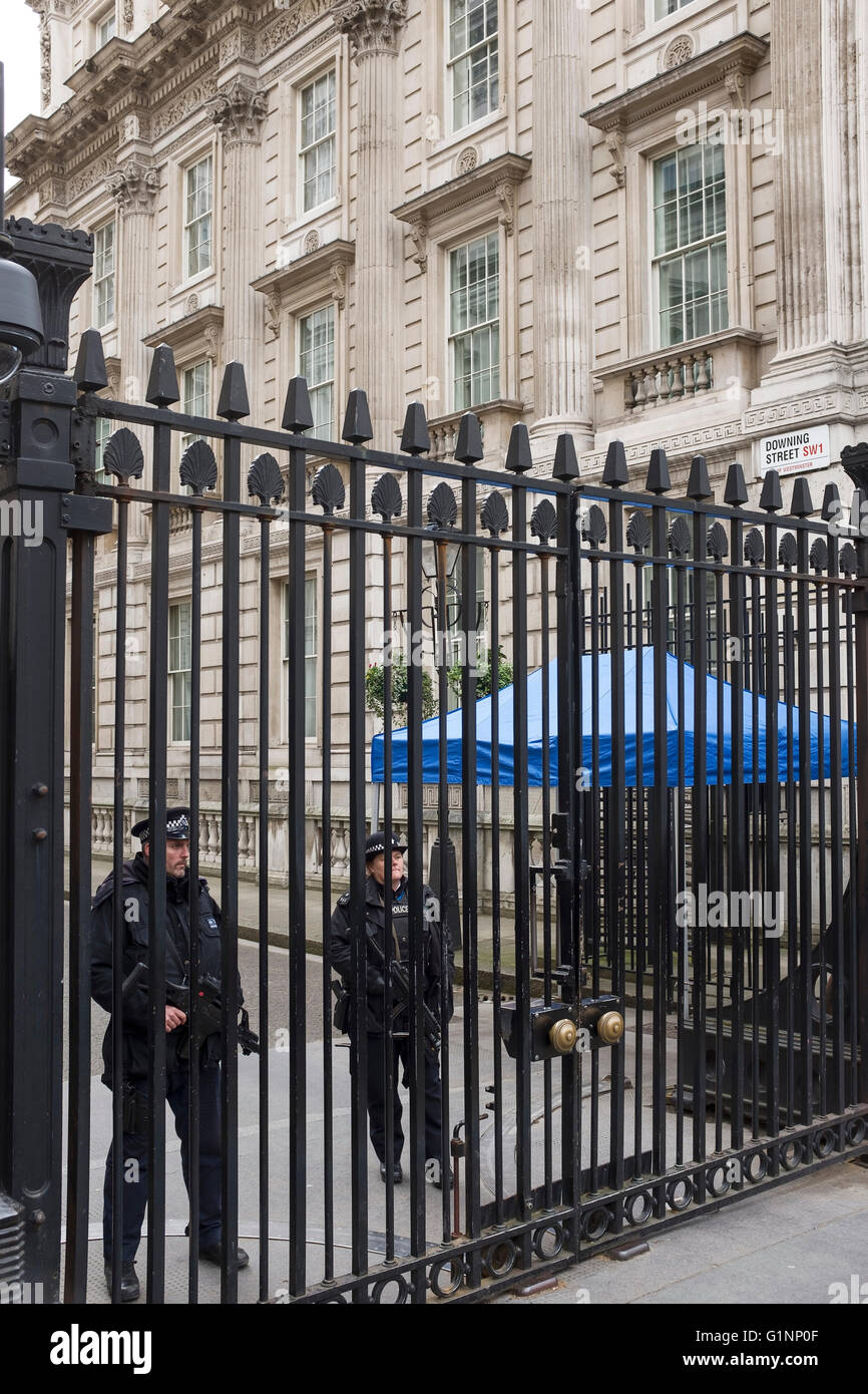 Bewaffnete Polizisten stehen hinter den Sicherheitsschleusen am Eingang zur Downing Street, London UK Stockfoto