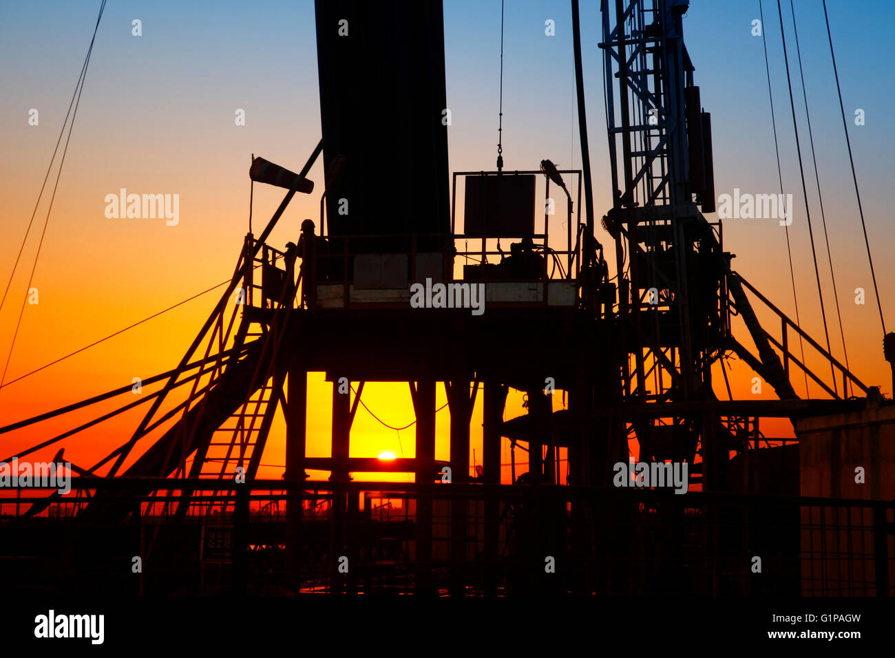Am Abend des Ölfeld, Pumpen-Einheit und die Silhouette der Ölfeld-derrick Stockfoto
