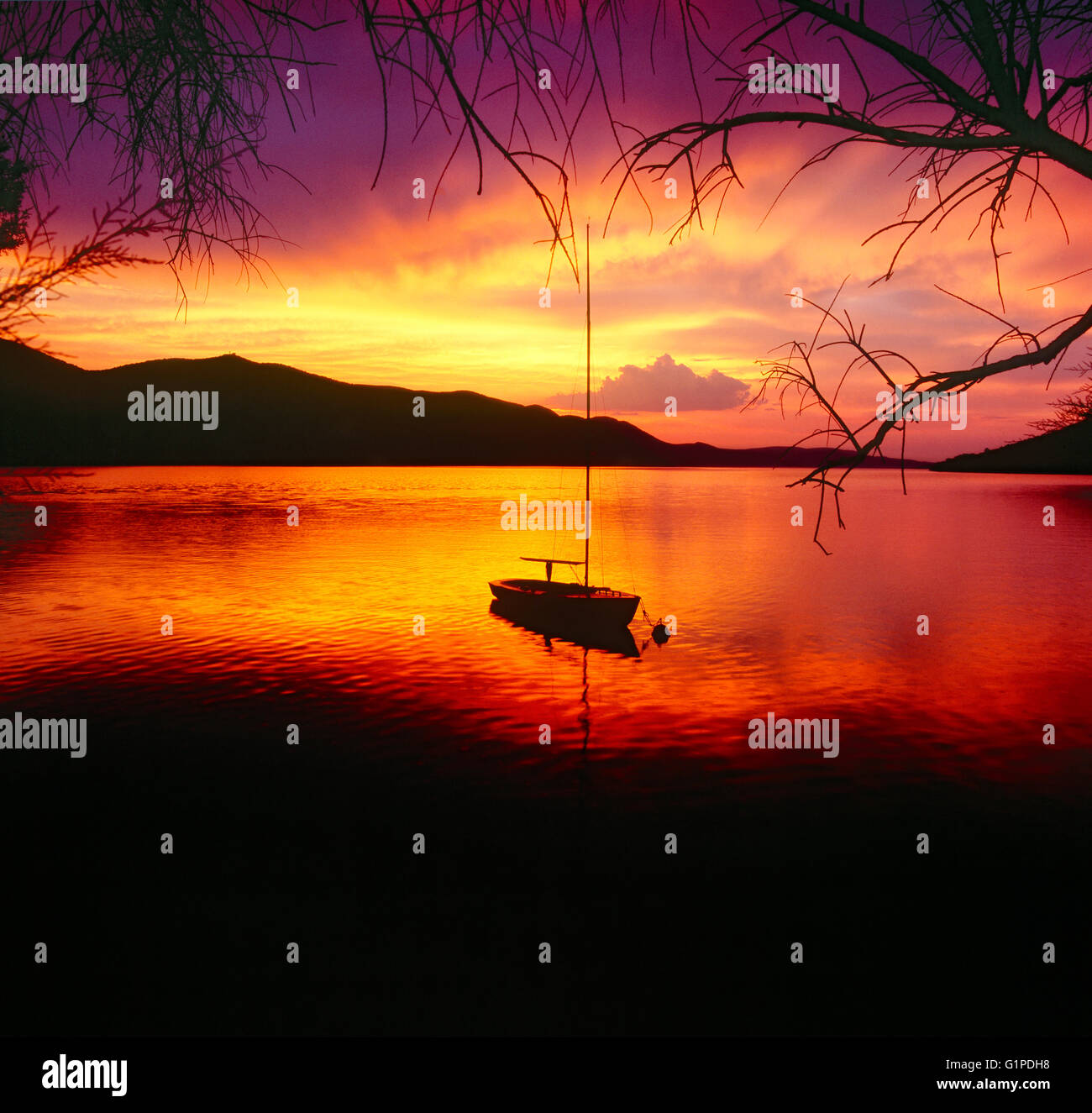 Ein einsames Boot an farbenprächtigen Sonnenuntergang Stockfoto