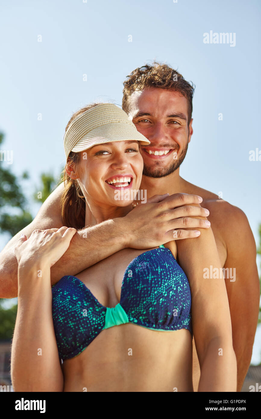 Paar im Urlaub am Strand umarmen einander glücklich Stockfoto