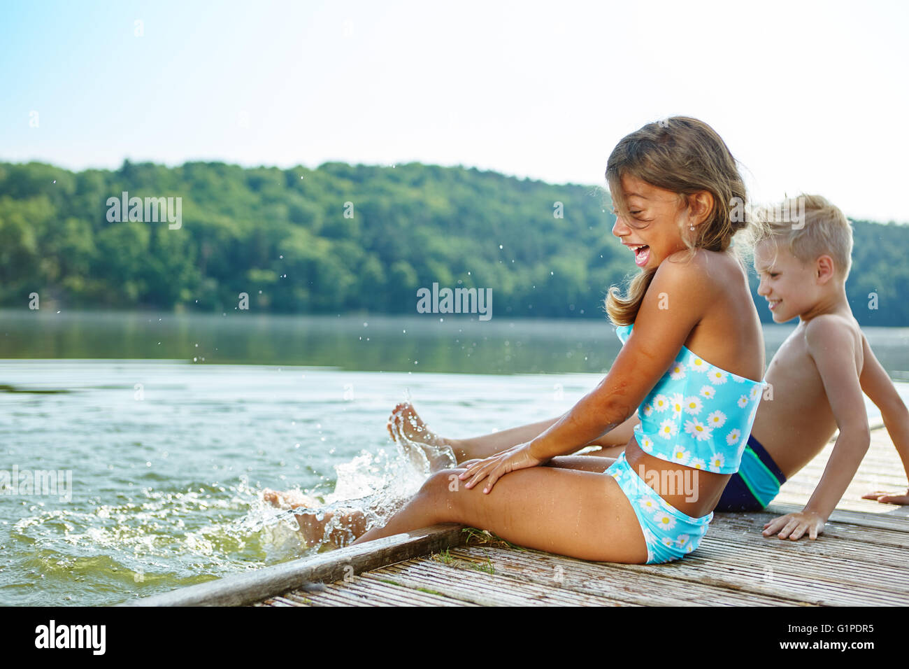 Zwei Kinder Spaß Spritzwasser mit den Füßen im Sommer Stockfoto