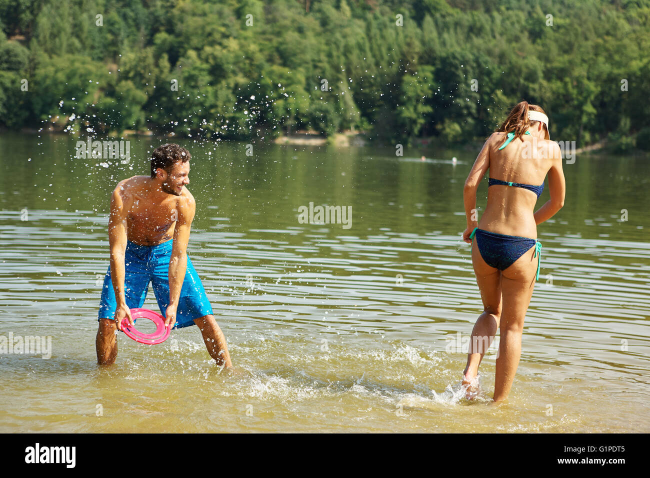 Glückliches Paar Sprühwasser zueinander und Spaß im Sommer Stockfoto