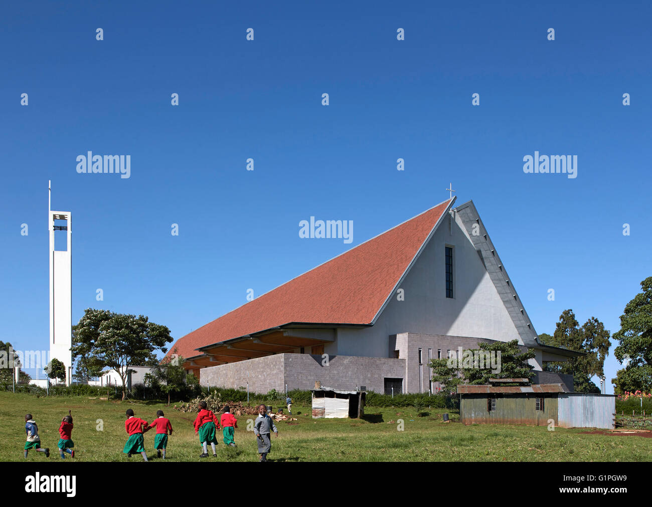 Gesamtansicht vom Feld unten mit Schulkindern auf Pause. Sacred Heart Cathedral der katholischen Diözese von Kericho, Kericho, Kenia. Architekt: John McAslan & Partner, 2016. Stockfoto