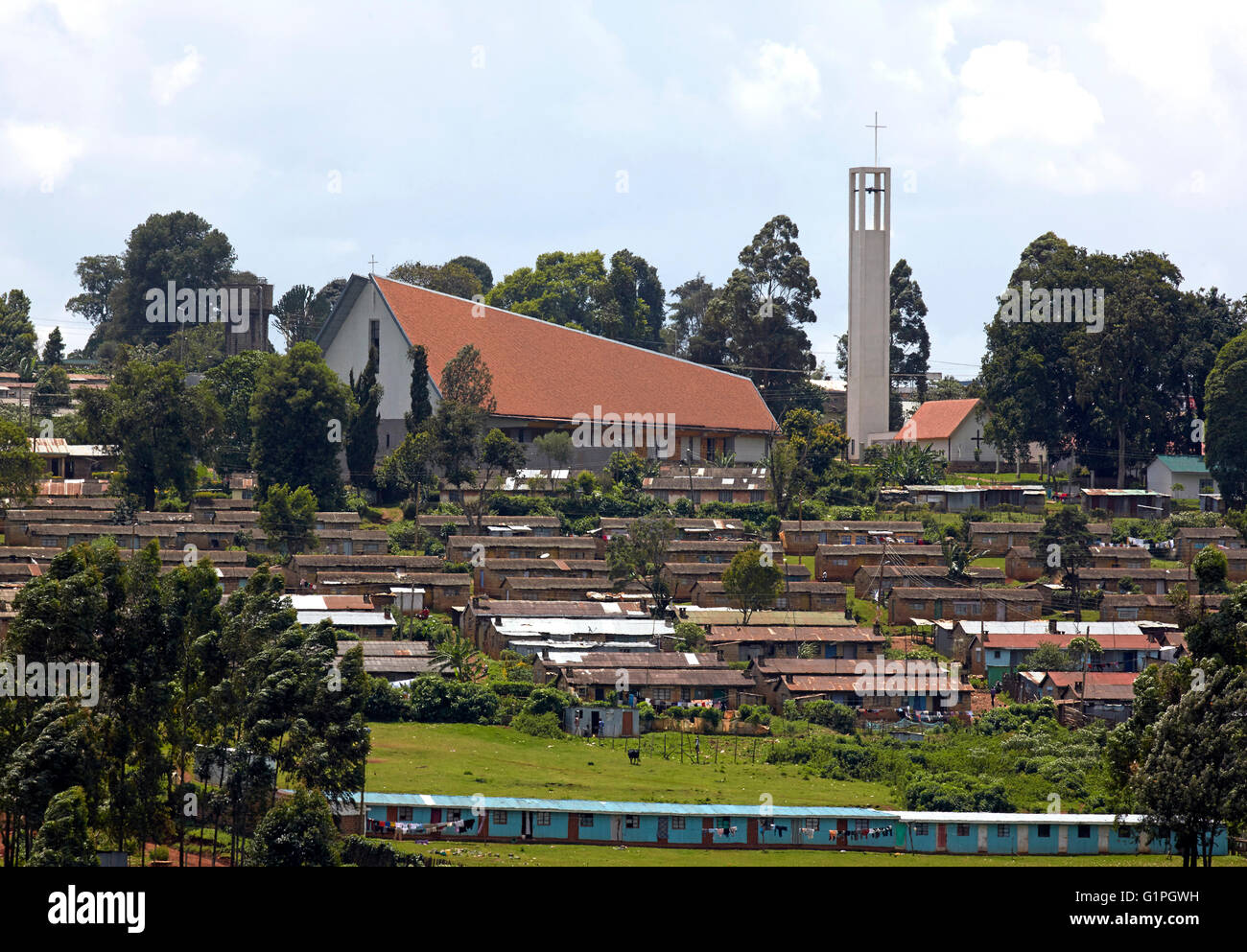Fernblick über Teeplantagen und lokale Gehäuse. Sacred Heart Cathedral der katholischen Diözese von Kericho, Kericho, Kenia. Stockfoto