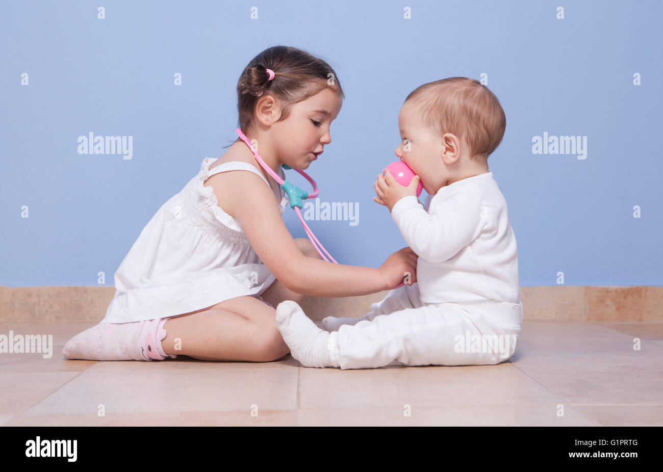 Babyschwester Bruder und Kleinkind spielen Arzt mit Stethoskop Stockfoto