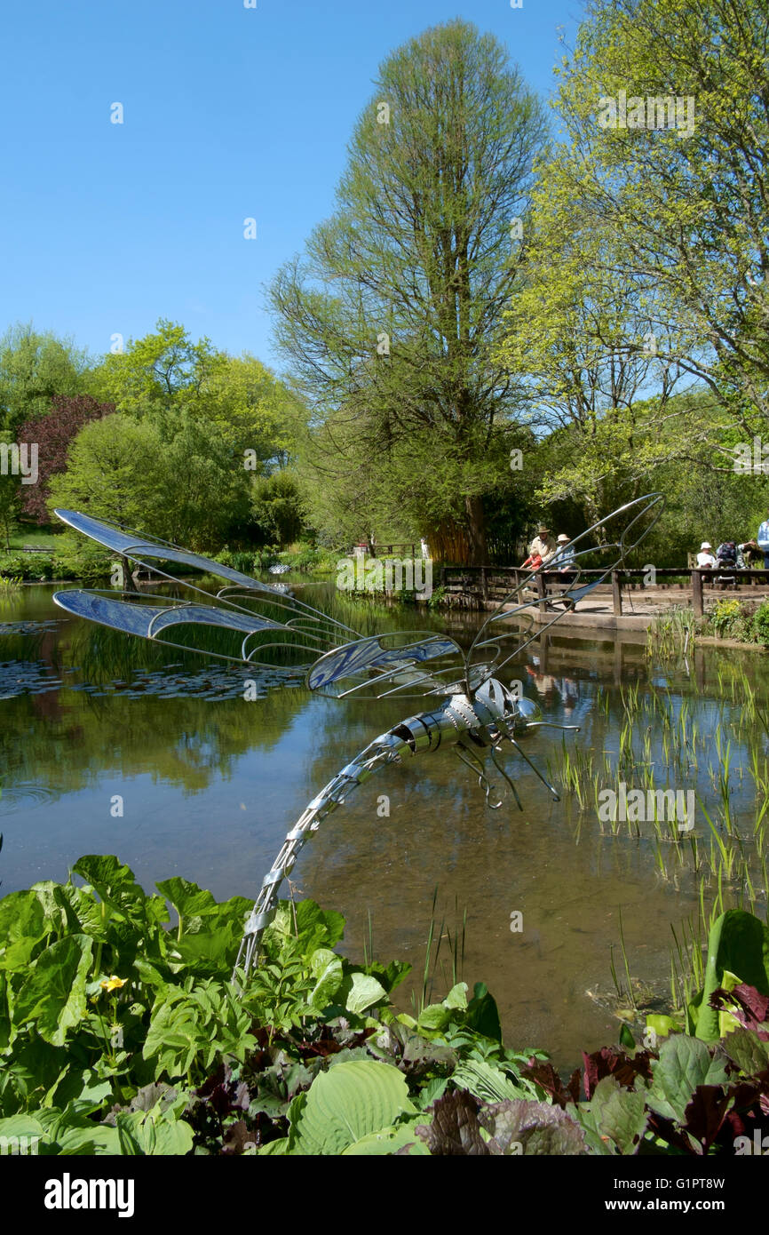 Libelle-Skulptur mit Blick auf einen Teich in Sir Harold hügeliger Gärten in Romsey England uk Stockfoto