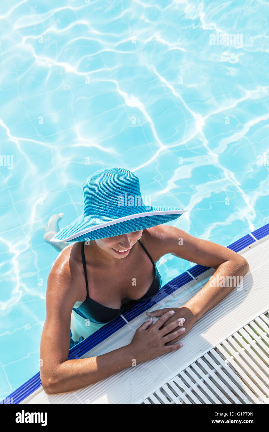 Frau in Sonnenhut im Schwimmbad. Ansicht von oben. Stockfoto