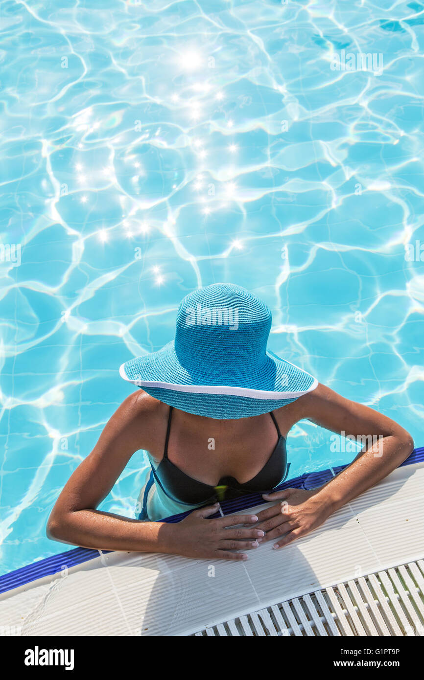 Frau in Sonnenhut im Schwimmbad. Ansicht von oben. Stockfoto