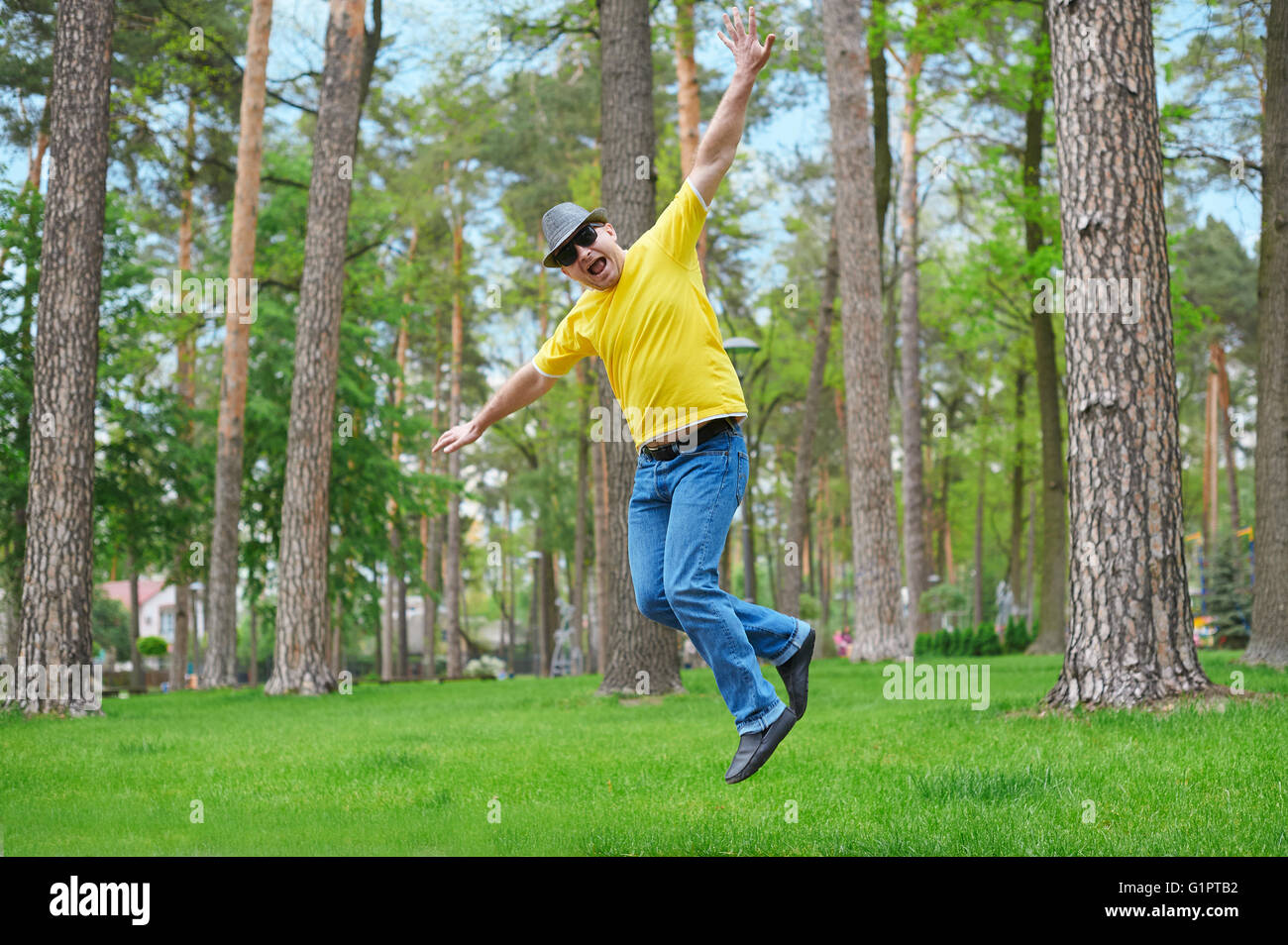 Netten Mann springt im Park am sonnigen Tag Stockfoto