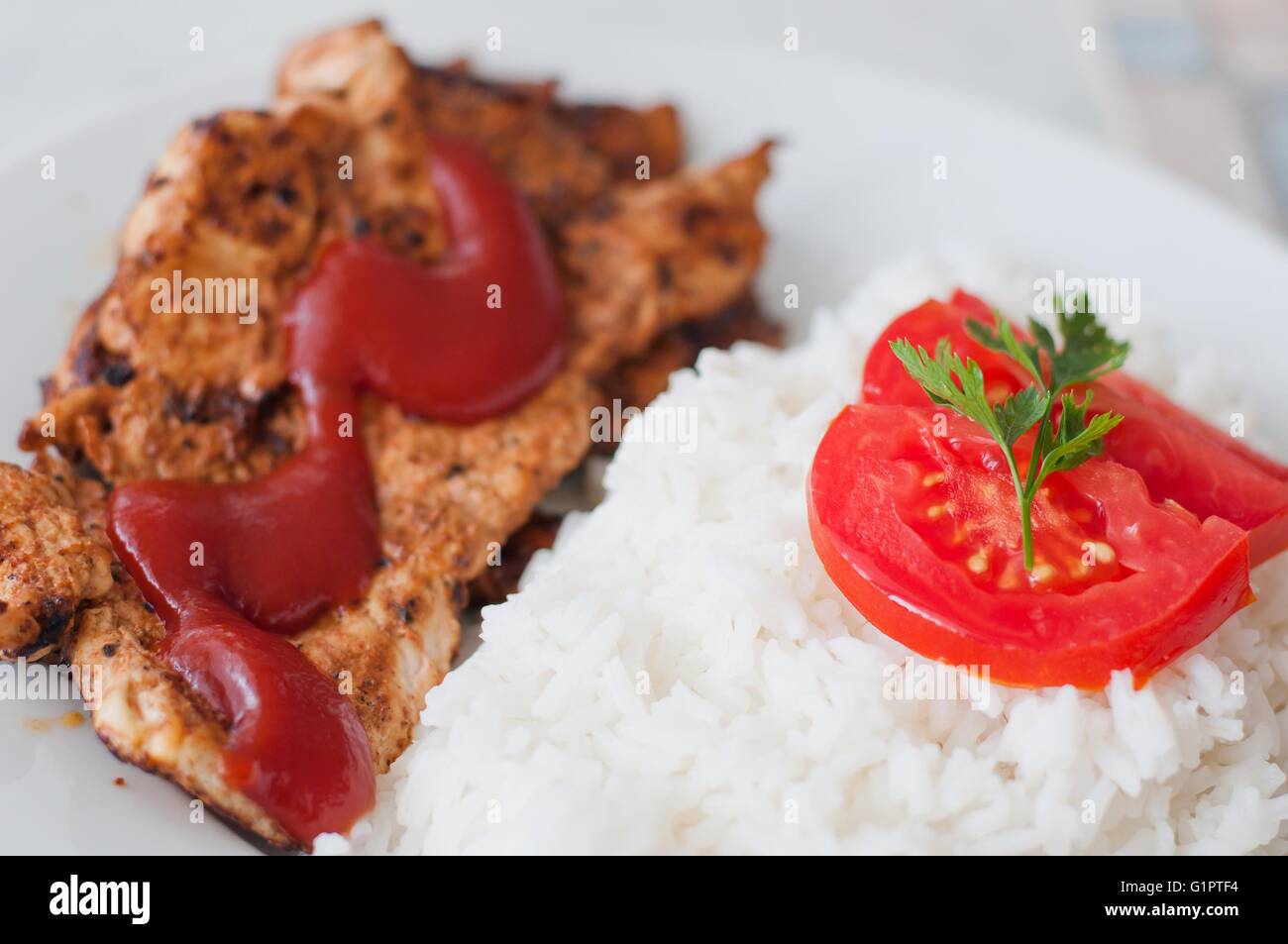 Hähnchensteak in einer Schale serviert mit Reis und Tomaten Scheibe Stockfoto