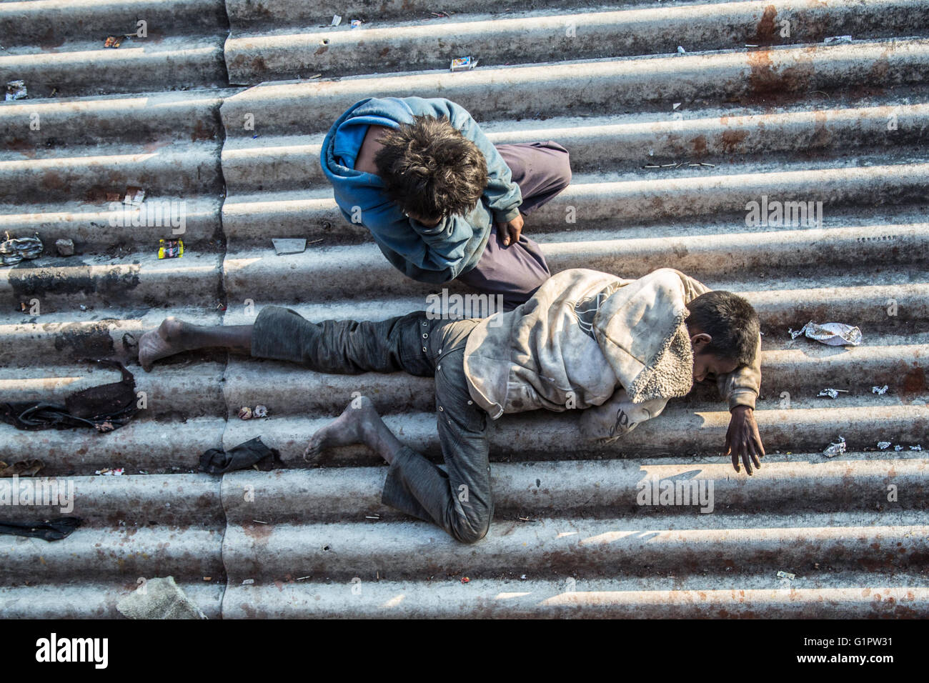 Ein Bild, am Morgen, nach unten auf zwei obdachlose Kinder schlafen auf einem Dach in der Nähe eines Bahnhofs in Janwar, Indien. Stockfoto