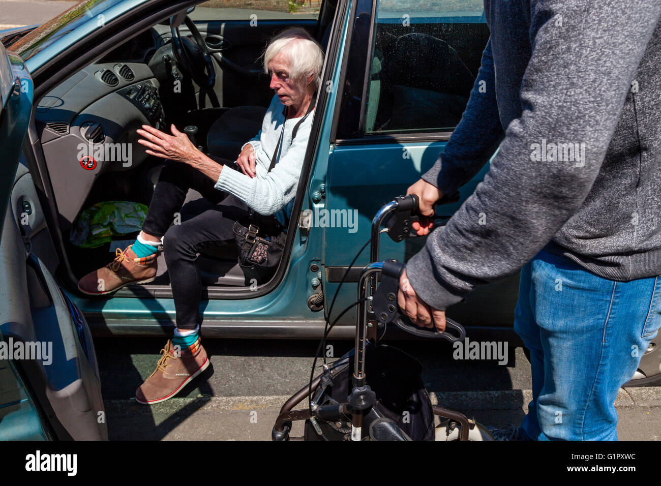 Eine ältere behinderte Frau, die immer aus einem Auto, Brighton, Sussex, UK Stockfoto