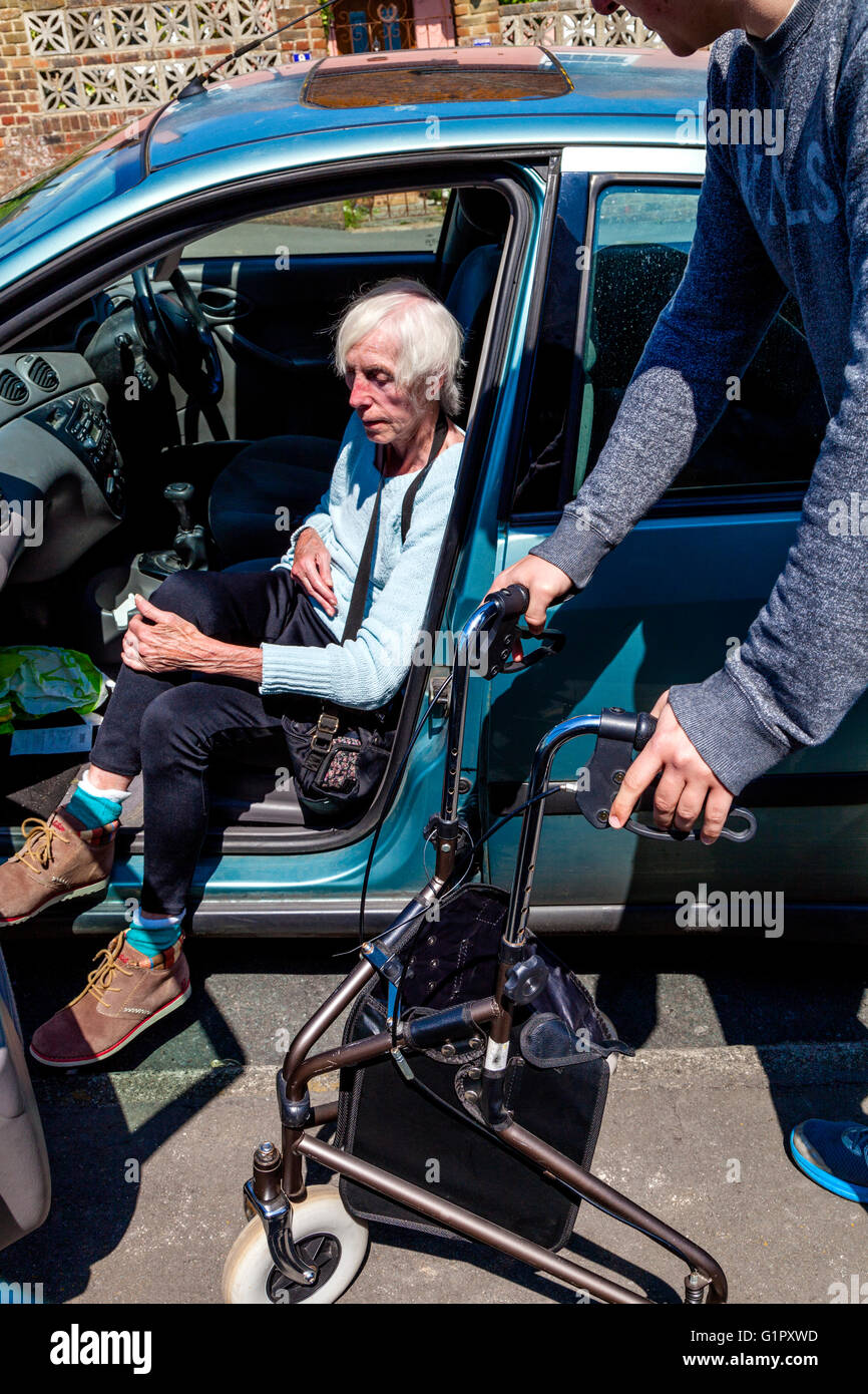 Eine ältere behinderte Frau, die immer aus einem Auto, Brighton, Sussex, UK Stockfoto