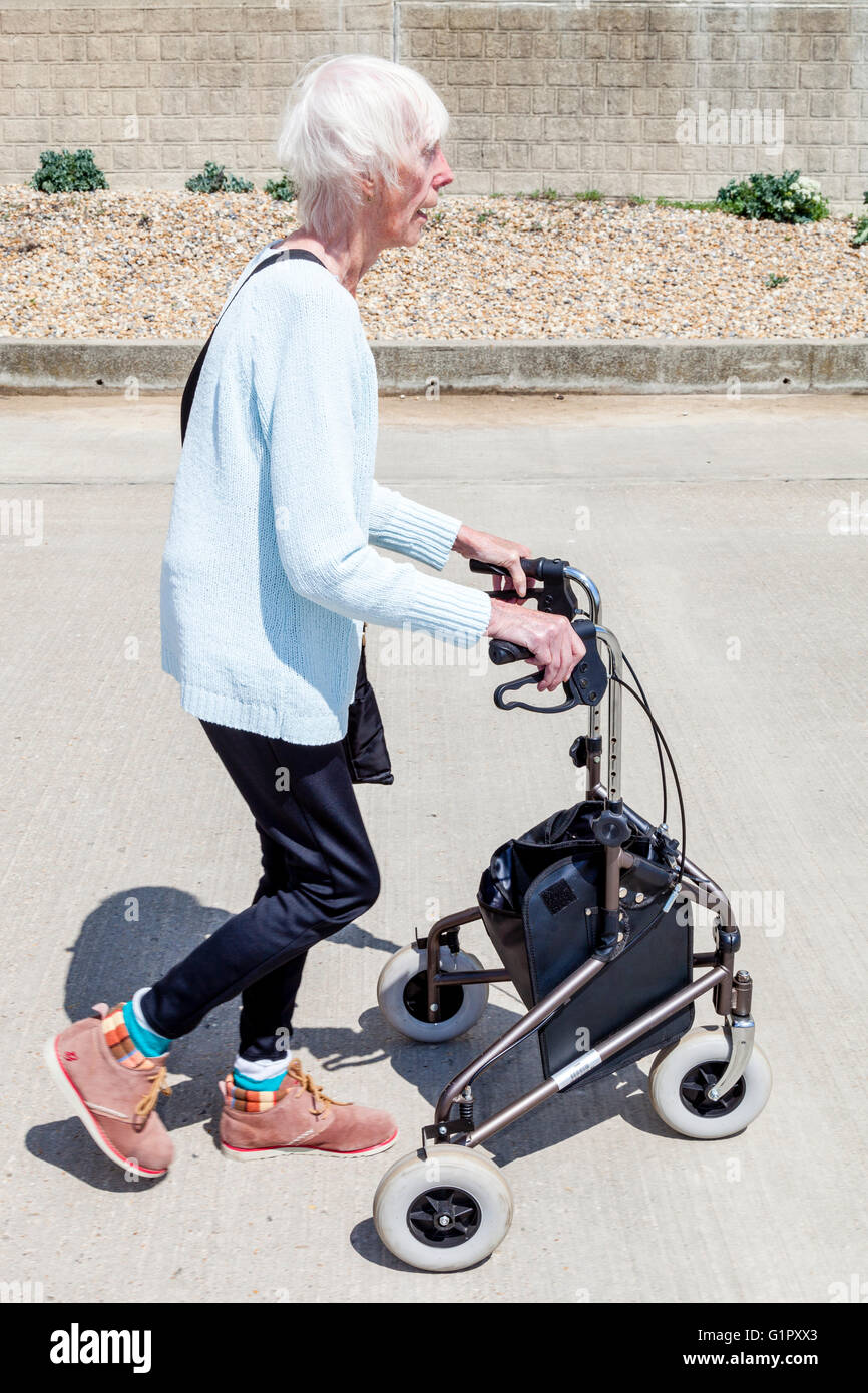 Eine ältere deaktiviert Frau mit einem Rollator zu Fuß Hilfe, Brighton, Sussex, UK Stockfoto