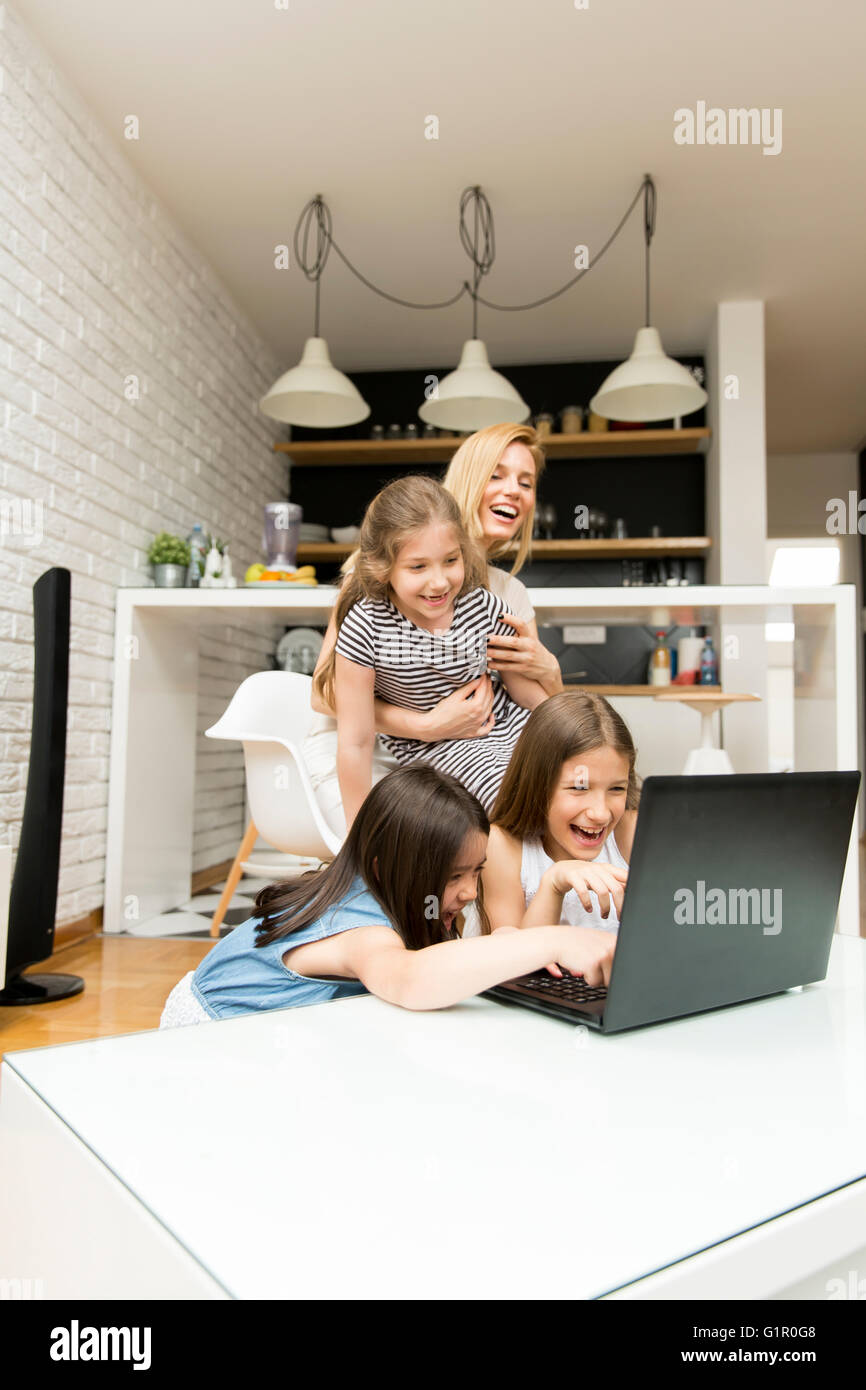 Frau mit Mädchen auf dem Laptop zu Hause Stockfoto